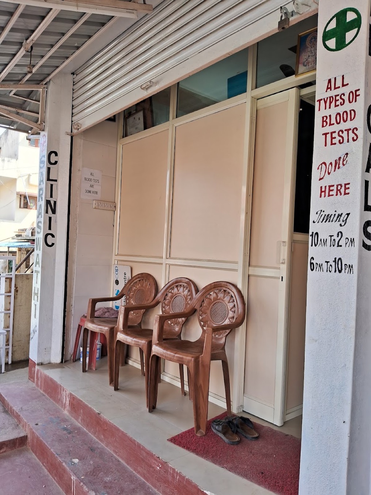 Saraswathi Clinic entrance on Hennur Village Road, with a sign for on-site blood tests