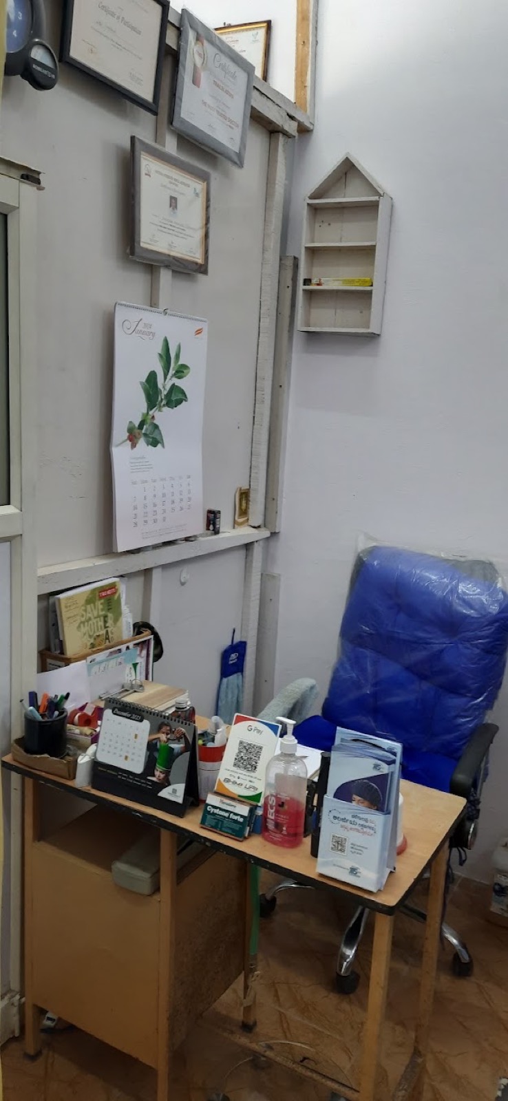 Dr. Venkatesh Mahagave's consultation desk at Saraswathi Clinic, with practice certificates on the wall